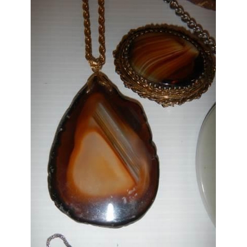 300 - An amber pendant, two agate pendants, two agate brooches etc.,