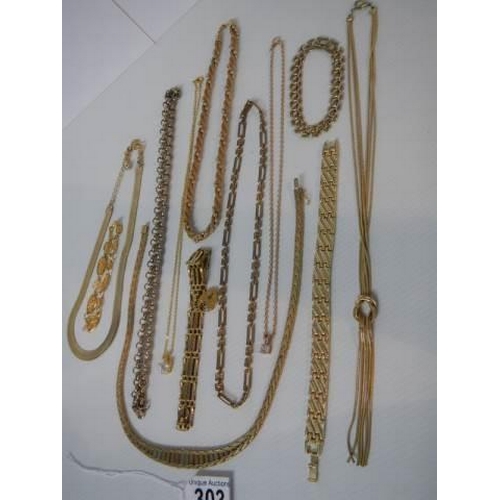 303 - Ten pieces of yellow metal jewellery (chains, necklaces and brooches).