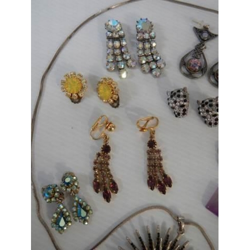 307 - A sunburst pendant and twelve pairs of assorted earrings.