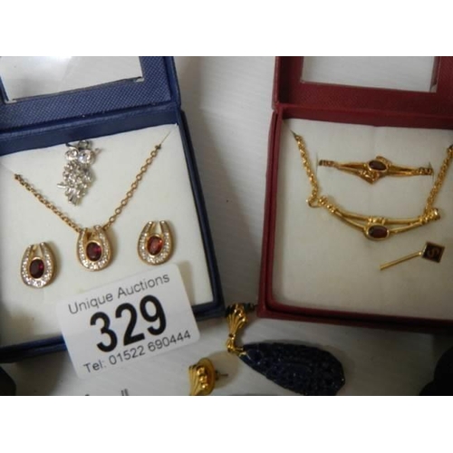 329 - A mixed lot including pendants with matching earrings, sets of buttons etc.,