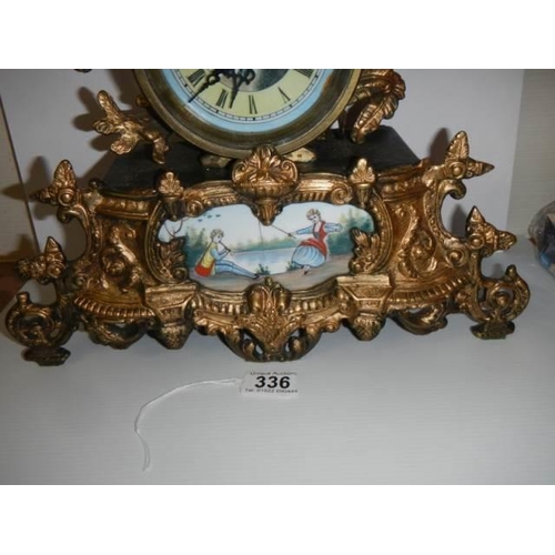 336 - A good 20th century mantel clock surmounted figure and with handpainted dial and panel, with battery... 