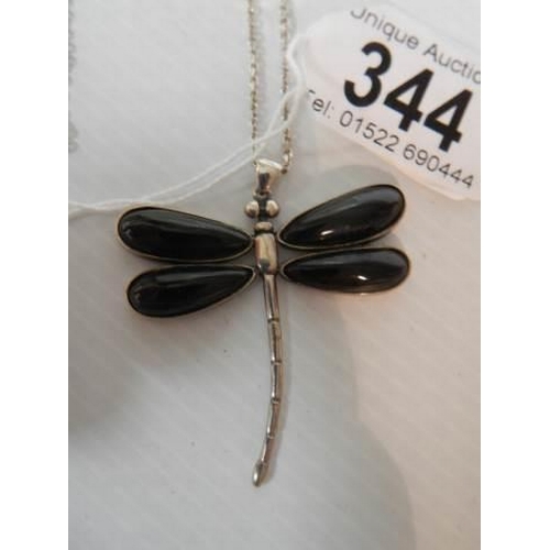 344 - A silver dragonfly pendant with black onyx wings on a silver chain.