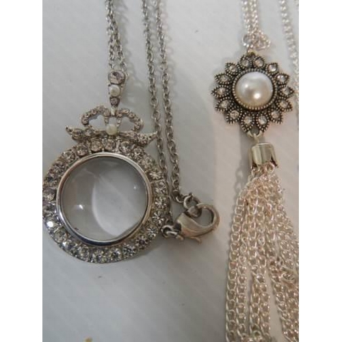 347 - A quantity of necklaces including magnifying glass pendant.