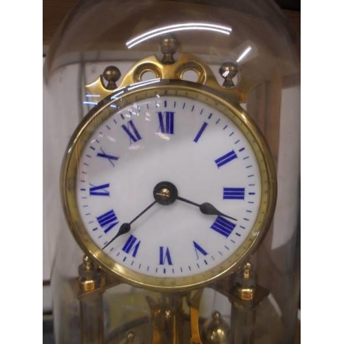 1218 - A good quality brass anniversary clock with enamel dial and under a plastic dome.