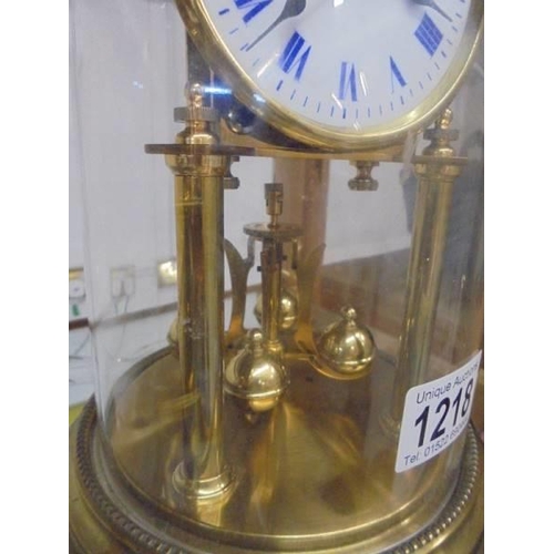 1218 - A good quality brass anniversary clock with enamel dial and under a plastic dome.