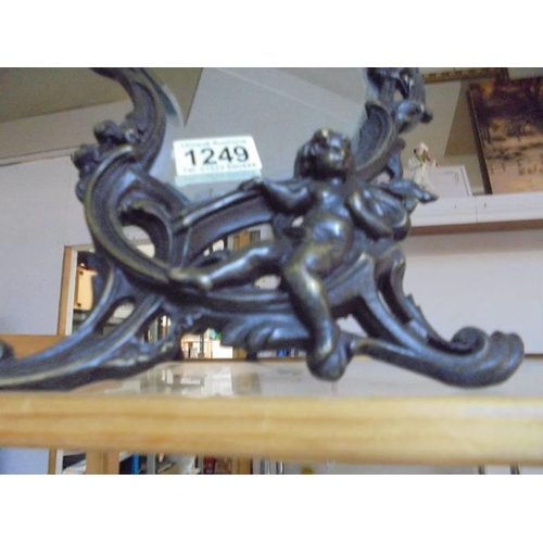 1249 - A metal framed art nouveau style mirror featuring cherubs.