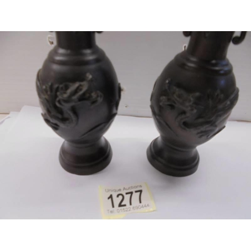 1277 - A pair of bronze vases with applied dragons, 17 cm tall.