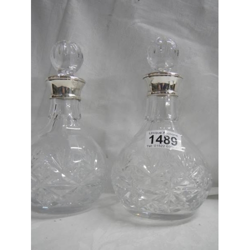 1489 - A pair of good cut glass decanters with hall marked silver collars.