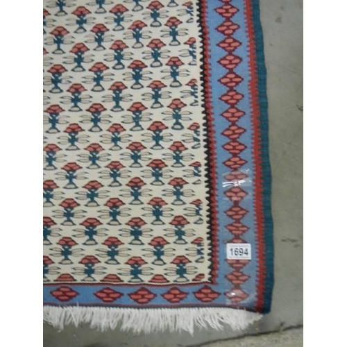 1694 - A 70 x 110 cm patterned reversible rug.