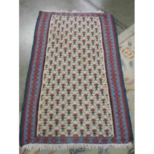 1694 - A 70 x 110 cm patterned reversible rug.