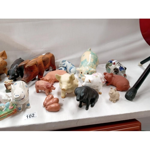 102 - A good lot of pigs, wood, ceramic etc