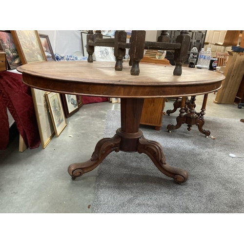 256 - A mahogany oval dining table with carved single pedestal on castors  139 x 104 x 76cms high top sun ... 