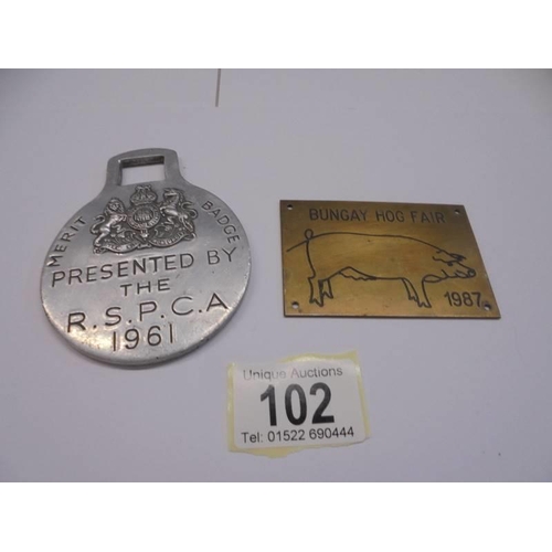 102 - A 1961 RSPCA merit badge and a Bungay Hog Fair 1987 brass plaque.