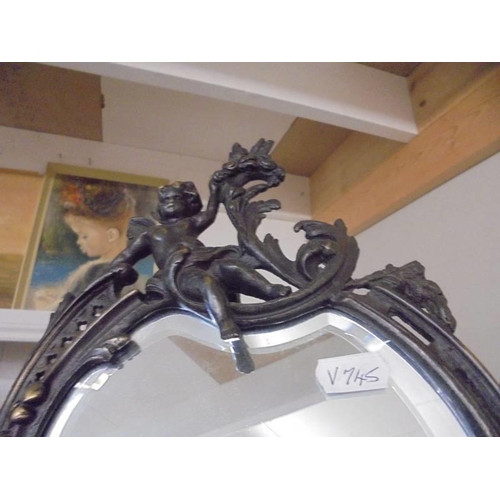 202 - A cast metal framed mirror in the art nouveau style featuring cherubs.