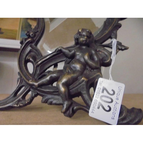 202 - A cast metal framed mirror in the art nouveau style featuring cherubs.