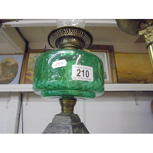 210 - An early 20th century oil lamp on cast iron base with green glass font and chimney. COLLECT ONLY.