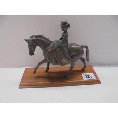 229 - A bronze figure of a lady riding a horse side saddle, length 18cm, height 15.5 cm.