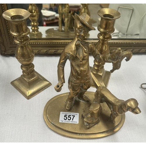 557 - A solid brass figure of a gamekeeper with dog & A pair of candlesticks with pushers