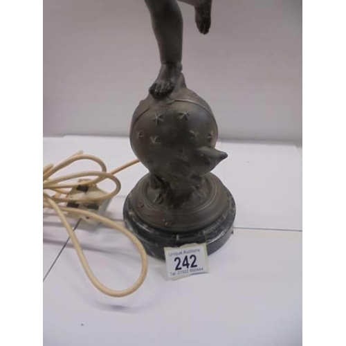 242 - A table lamp on marble base featuring a cherub on a globe complete with flame shade, COLLECT ONLY.