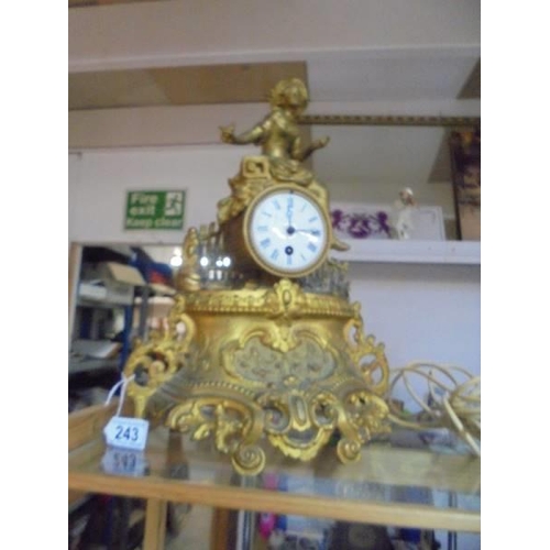 243 - A 19th century gilded mantel clock surmounted figure, in working order.