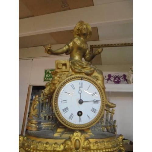 243 - A 19th century gilded mantel clock surmounted figure, in working order.