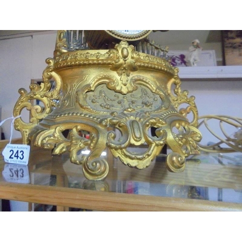 243 - A 19th century gilded mantel clock surmounted figure, in working order.