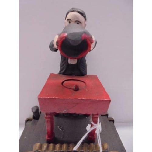 247 - A cast iron magician money bank.