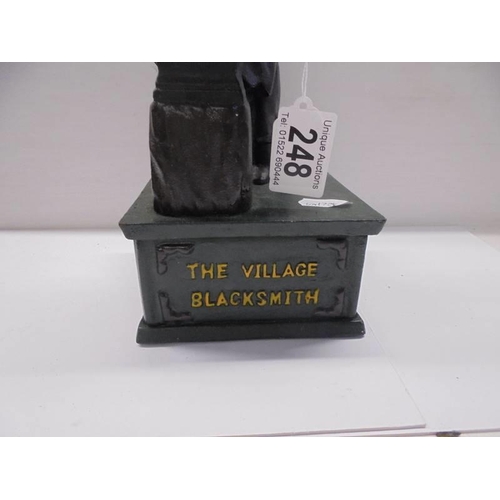 248 - A cast iron The Village Blacksmith money bank.