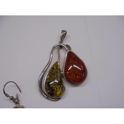 67 - A silver and amber pendant together with a pair of silver and amber earrings, (925).