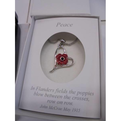 68 - A poppy necklace and a sparkly articulated teddy bear brooch.