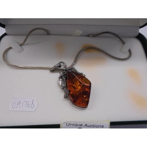 69 - A silver and amber pendant on a 41 cm chain in original box.