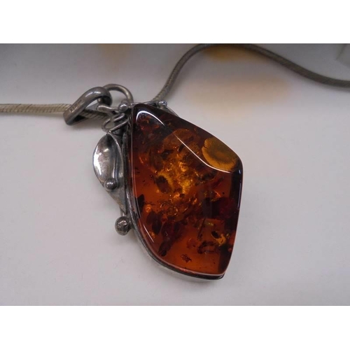 69 - A silver and amber pendant on a 41 cm chain in original box.