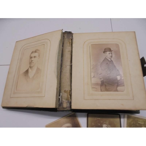 84 - A small Victorian photo album (spine needs repair) and loose photographs.