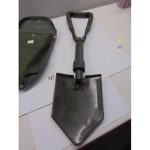 127 - A cased folding trench shovel (unused).