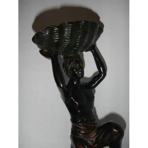 345 - An early 20th century bronze figure of a man holding a shell.