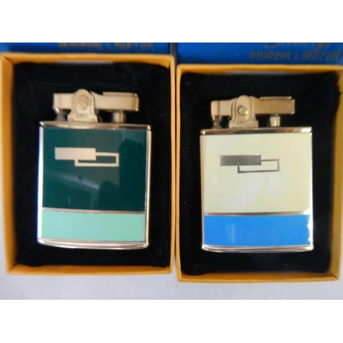 142 - Two boxed Canary Singing cigarette lighters.