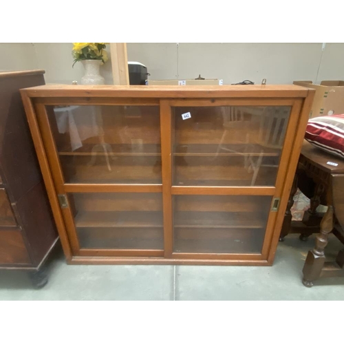 442 - A vintage pine bookcase with sliding glazed doors