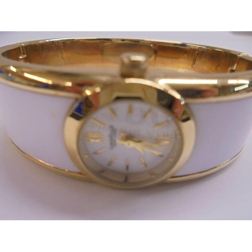 1001 - A Caravelle New York white enamel bangle watch, in working order.