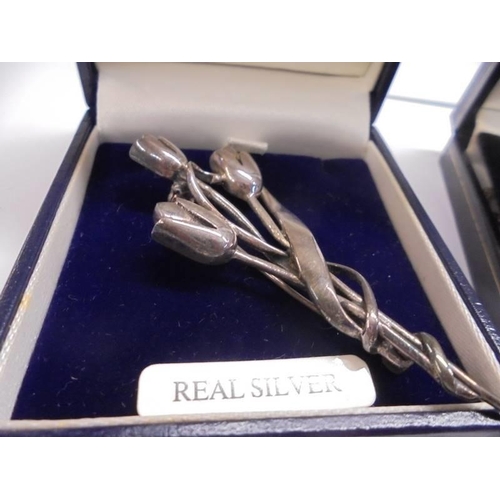 1004 - A silver National Trust flower brooch and a silver cross on silver chain