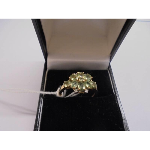 1011 - A 9ct gold ring set green stones, size P, 2.5 grams.