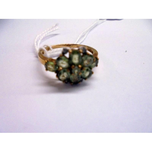 1011 - A 9ct gold ring set green stones, size P, 2.5 grams.