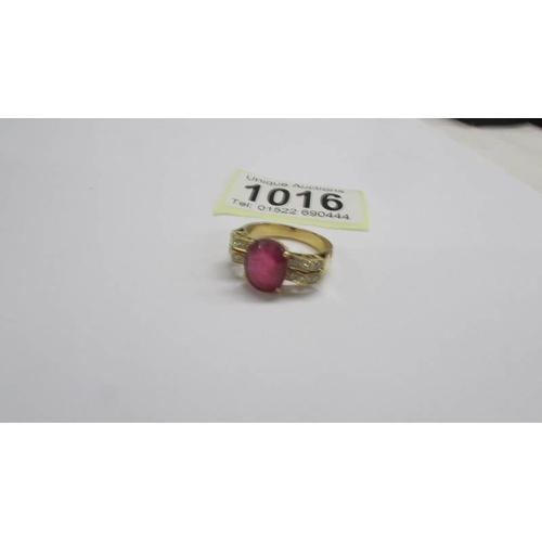 1016 - An 18ct white/yellow gold oval ruby and diamond ring, size O half, 6.2 grams.