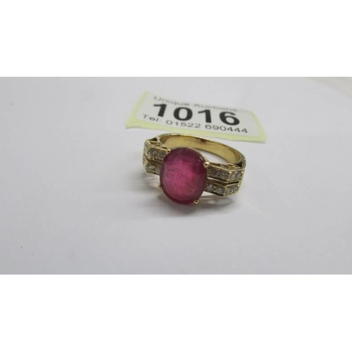 1016 - An 18ct white/yellow gold oval ruby and diamond ring, size O half, 6.2 grams.