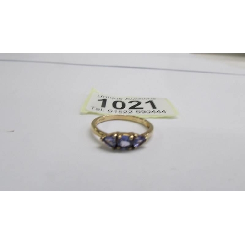 1021 - A yellow gold three stone tanzanite and diamond ring, size P half, 2 grams.