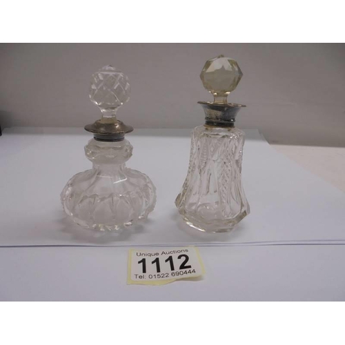 1112 - Two glass scent bottles with silver collars.