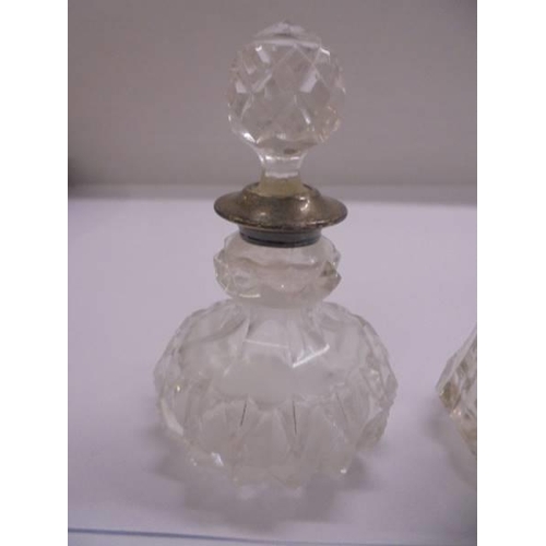 1112 - Two glass scent bottles with silver collars.