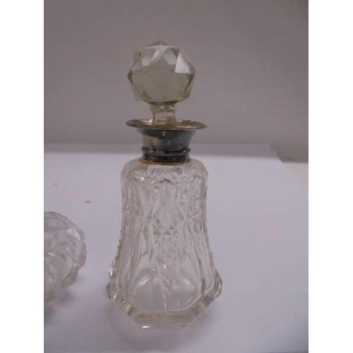 1112 - Two glass scent bottles with silver collars.