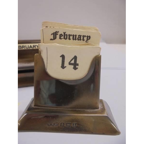 1114 - A silver perpetual desk calendar and a brass example.