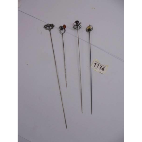 1134 - Four early 20th century silver hat pins.