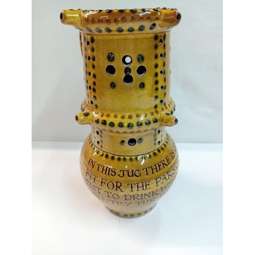 1251 - A Bideford pottery double height puzzle jug. Height 24cm